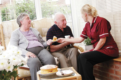 Image: Nurse giving couple cake