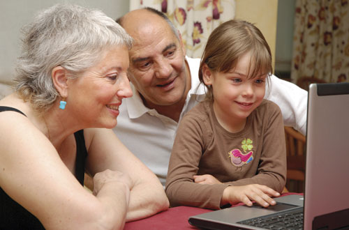 Photo: Parents and a kid using a laptop