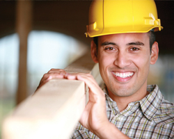Image: Smiling working carrying timber