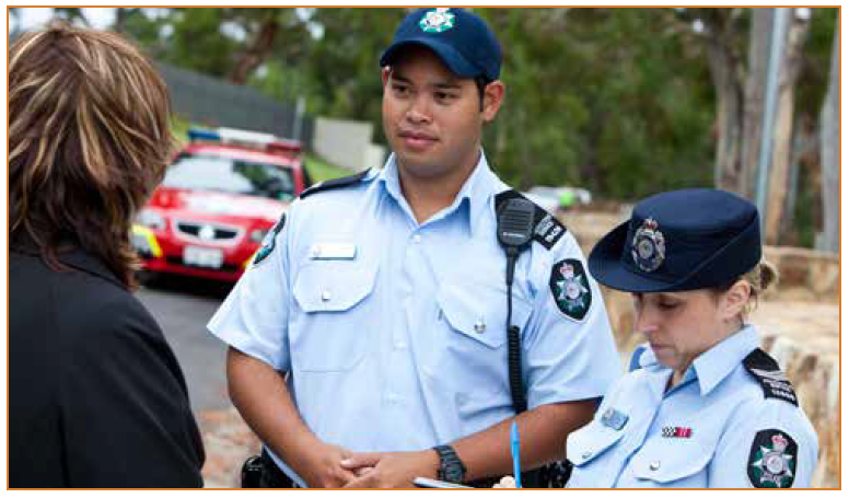 Photo of police officers speaking to a member of the community.