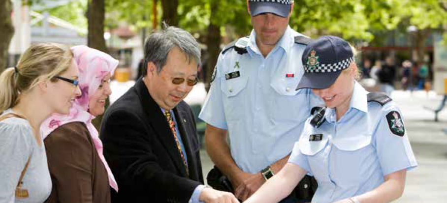 Photo of two police officers speaking to members of the community.